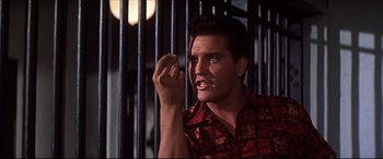 Movie still from “Blue Hawaii” (1961), directed by Norman Taurog – A man holding a cell phone up to his face; Close Up shot, Low angle
