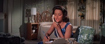 Movie still from “Blue Hawaii” (1961), directed by Norman Taurog – A woman sitting at a table talking on the phone; Medium shot, High angle