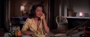 Movie still from “Blue Hawaii” (1961), directed by Norman Taurog – A woman sitting at a table talking on a phone; Medium shot, High angle