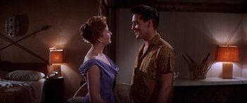 Movie still from “Blue Hawaii” (1961), directed by Norman Taurog – A man and a woman standing next to each other; Medium shot, Over the shoulder angle