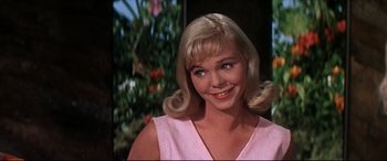 Movie still from “Blue Hawaii” (1961), directed by Norman Taurog – A person with blonde hair wearing a pink dress; Close Up shot, Low angle