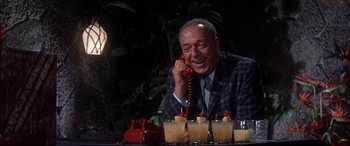 Movie still from “Blue Hawaii” (1961), directed by Norman Taurog – An older man sitting at a table talking on the phone; Medium shot, High angle