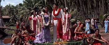 Movie still from “Blue Hawaii” (1961), directed by Norman Taurog – A man standing next to a group of women; Wide shot, Low angle