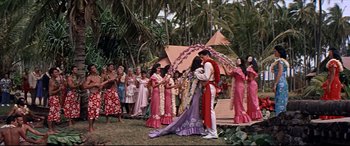 Movie still from “Blue Hawaii” (1961), directed by Norman Taurog – A group of people standing in a grassy area; Wide shot, High angle