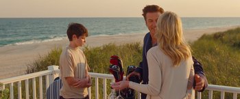 Movie still from “Blue Jasmine” (2013), directed by Woody Allen – A group of people standing next to each other near the ocean; Medium shot, Over the shoulder angle