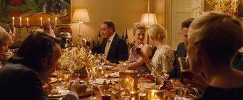 Movie still from “Blue Jasmine” (2013), directed by Woody Allen – A group of people sitting around a table with wine glasses; Medium shot, High angle