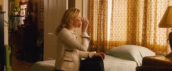 Movie still from “Blue Jasmine” (2013), directed by Woody Allen – A woman sitting on a couch drinking from a cup; Medium shot, High angle