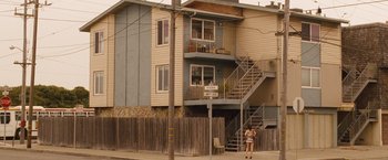 Movie still from “Blue Jasmine” (2013), directed by Woody Allen – A woman standing on the side of the street in front of an apartment building; Extreme Wide shot, Low angle