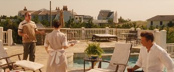 Movie still from “Blue Jasmine” (2013), directed by Woody Allen – A woman holding a tray of food near a swimming pool; Wide shot, Over the shoulder angle