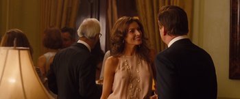 Movie still from “Blue Jasmine” (2013), directed by Woody Allen – A group of people standing next to each other at an event; Medium shot, Over the shoulder angle