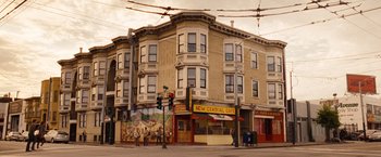 Movie still from “Blue Jasmine” (2013), directed by Woody Allen – People are standing on the sidewalk in front of a building; Extreme Wide shot, Low angle
