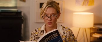 Movie still from “Blue Jasmine” (2013), directed by Woody Allen – A woman with glasses reading a computer book; Close Up shot, Over the shoulder angle