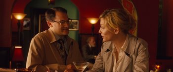 Movie still from “Blue Jasmine” (2013), directed by Woody Allen – A man and a woman sitting at a table with a drink; Medium shot, Over the shoulder angle