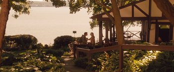 Movie still from “Blue Jasmine” (2013), directed by Woody Allen – A man and a woman sitting on a bench by the water; Wide shot, High angle