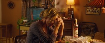 Movie still from “Blue Jasmine” (2013), directed by Woody Allen – A woman sitting at a table with her head in her hands; Medium shot, High angle