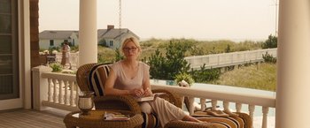Movie still from “Blue Jasmine” (2013), directed by Woody Allen – A woman sitting in a chair on a porch; Medium shot, Over the shoulder angle