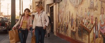 Movie still from “Blue Jasmine” (2013), directed by Woody Allen – A woman walking down the street holding a purse; Medium shot, Over the shoulder angle