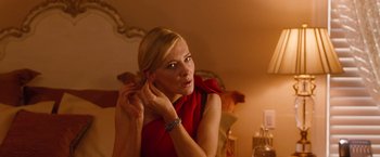 Movie still from “Blue Jasmine” (2013), directed by Woody Allen – A woman in a red dress putting on her earrings; Close Up shot, Over the shoulder angle