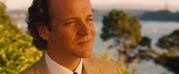 Movie still from “Blue Jasmine” (2013), directed by Woody Allen – A person wearing a suit and tie; Close Up shot, Over the shoulder angle