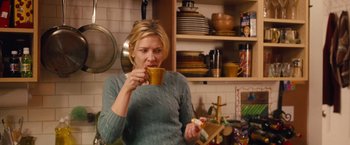 Movie still from “Blue Jasmine” (2013), directed by Woody Allen – A woman drinking a cup of coffee in a kitchen; Medium shot, Over the shoulder angle