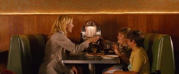 Movie still from “Blue Jasmine” (2013), directed by Woody Allen – A woman sitting at a table with a young boy; Medium shot, Low angle