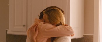 Movie still from “Blue Jasmine” (2013), directed by Woody Allen – A woman hugging another woman in front of a mirror; Medium shot, Over the shoulder angle