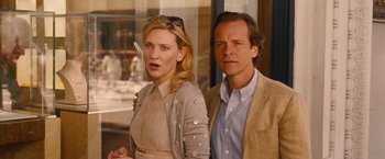 Movie still from “Blue Jasmine” (2013), directed by Woody Allen – A man and a woman standing next to each other in front of a window; Medium shot, Over the shoulder angle