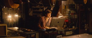 Movie still from “Blue Jasmine” (2013), directed by Woody Allen – A man sitting in front of an open laptop computer; Medium shot, Over the shoulder angle