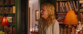 Movie still from “Blue Jasmine” (2013), directed by Woody Allen – A woman standing in front of a door looking at something; Medium shot, Over the shoulder angle