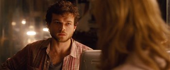 A man sitting in front of a mirror looking at a woman