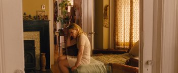 Movie still from “Blue Jasmine” (2013), directed by Woody Allen – A woman sitting on a bed in a living room; Wide shot, High angle