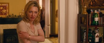 Movie still from “Blue Jasmine” (2013), directed by Woody Allen – A woman standing in front of a door in a room; Medium shot, Over the shoulder angle