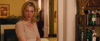 Movie still from “Blue Jasmine” (2013), directed by Woody Allen – A person standing in a room near a door; Close Up shot, Over the shoulder angle