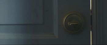 Movie still from “Blue Ruin” (2013), directed by Jeremy Saulnier – A door handle on a door; Extreme Close Up shot, Overhead angle