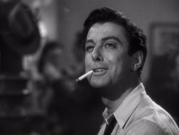 Movie still from “Blues in the Night” (1941), directed by Anatole Litvak – A black and white photo of a man smoking a cigarette; Close Up shot, Low angle