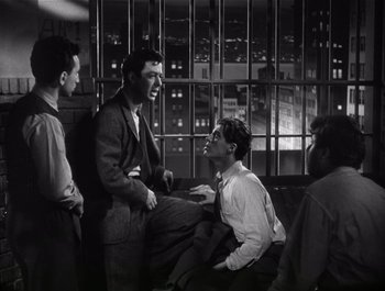 Movie still from “Blues in the Night” (1941), directed by Anatole Litvak – A group of men sitting next to each other in a room; Medium shot, Low angle