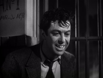 Movie still from “Blues in the Night” (1941), directed by Anatole Litvak – Black and white photograph of a man in a suit and tie; Close Up shot, Low angle