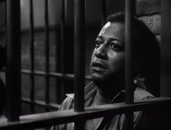 Movie still from “Blues in the Night” (1941), directed by Anatole Litvak – A black and white photo of a man in jail; Medium shot, Low angle