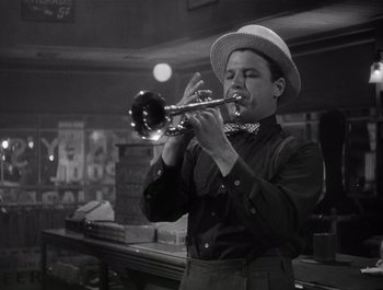 Movie still from “Blues in the Night” (1941), directed by Anatole Litvak – A man in a hat playing a trumpet; Medium shot, Low angle