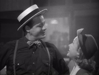 Movie still from “Blues in the Night” (1941), directed by Anatole Litvak – A man and a woman wearing hats and smiling at each other; Medium shot, Low angle