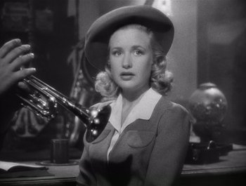 Movie still from “Blues in the Night” (1941), directed by Anatole Litvak – An old photo of a woman with a hat holding a trumpet; Close Up shot, Low angle