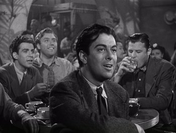 Movie still from “Blues in the Night” (1941), directed by Anatole Litvak – Black and white photograph of men drinking at a bar; Medium shot, Over the shoulder angle