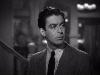 Movie still from “Blues in the Night” (1941), directed by Anatole Litvak – A man wearing a suit and tie in a black and white photo; Close Up shot, Low angle