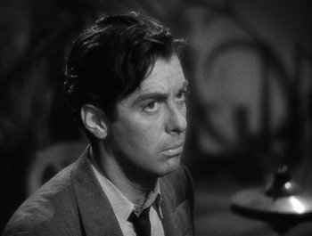 Movie still from “Blues in the Night” (1941), directed by Anatole Litvak – Black and white photograph of a man in a suit and tie; Close Up shot, Low angle