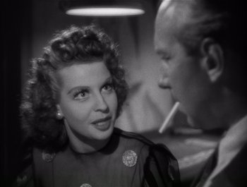 Movie still from “Blues in the Night” (1941), directed by Anatole Litvak – An old photo of a woman talking to a man; Close Up shot, Over the shoulder angle