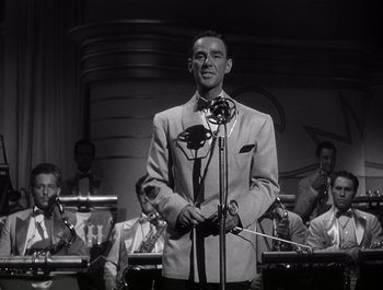 Movie still from “Blues in the Night” (1941), directed by Anatole Litvak – A black and white photo of a man singing; Medium shot, Low angle