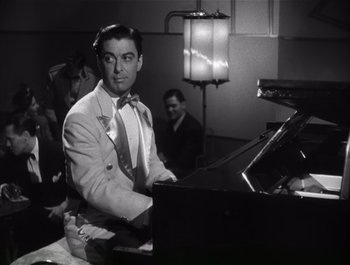 Movie still from “Blues in the Night” (1941), directed by Anatole Litvak – A black and white photo of a man sitting at a piano; Medium shot, Low angle