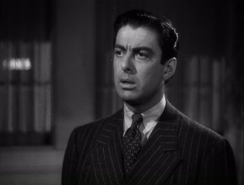 Movie still from “Blues in the Night” (1941), directed by Anatole Litvak – A black and white photo of a man wearing a suit; Close Up shot, Low angle