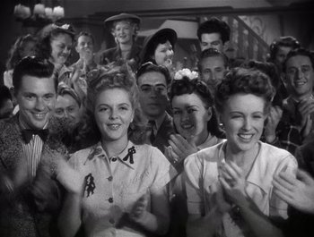 Movie still from “Blues in the Night” (1941), directed by Anatole Litvak – A group of people standing next to each other clapping; Medium shot, Low angle
