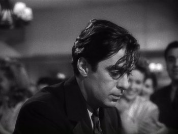 Movie still from “Blues in the Night” (1941), directed by Anatole Litvak – Black and white photograph of a man in a suit and tie; Close Up shot, Low angle